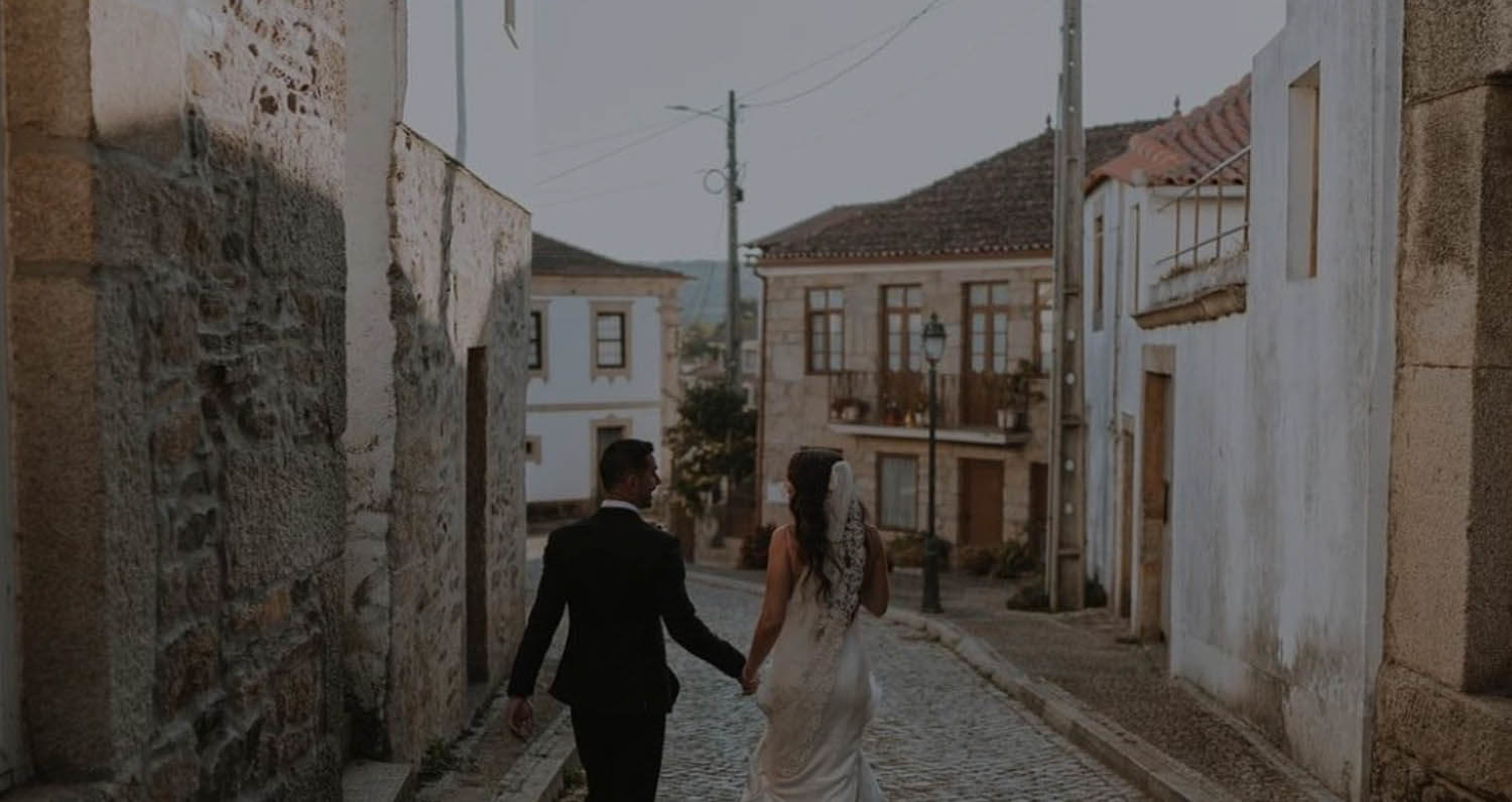 Сouple wearing a white gown and a black suit. Mobile image