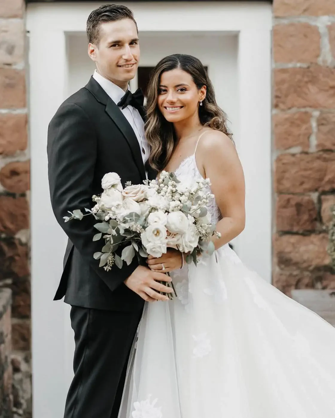 Сouple wearing a white gown and a black suit